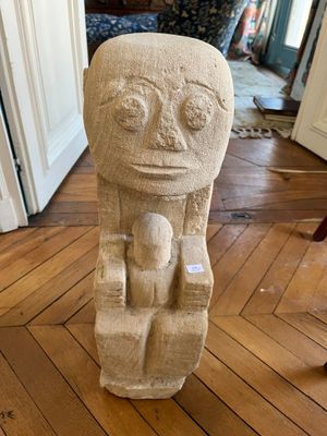 une statue représentant un homme assis sur une chaise dans un salon