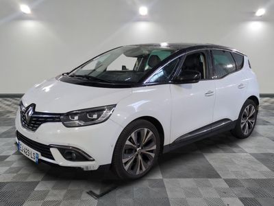la voiture blanche est garée sur un sol en damier dans le garage