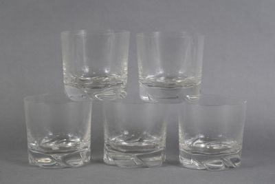 six glasses of different sizes and shapes are lined up on a gray surface