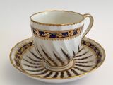a cup and saucer on a saucer on a white table