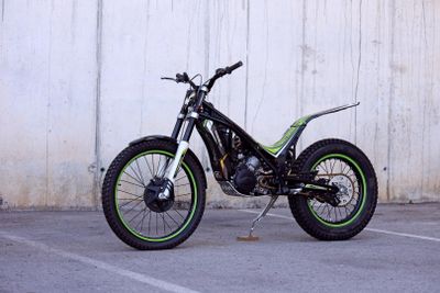 a motorcycle parked in a parking lot with a wall in the background