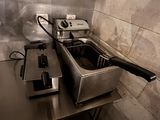 two deep fryers sitting on a table in a kitchen