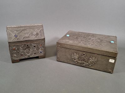 une paire de boîtes en argent ornées de motifs sur un fond gris