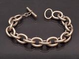 bracelet à chaîne plaquée argent avec fermoir, sur fond noir