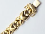 an image of a close up of a gold bracelet on a white surface
