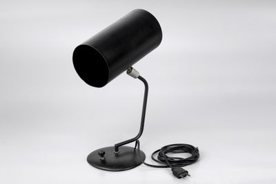 a black table lamp with a cord plugged into it