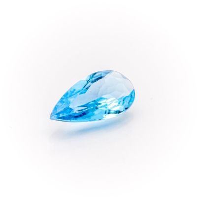 a close up of a blue topazte stone on a white surface