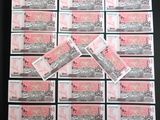 une pile de billets roses et blancs posée sur une table noire