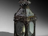a small metal lantern with a candle inside of it