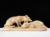 une photo représentant une sculpture d'un chien et d'un chat posée sur une table
