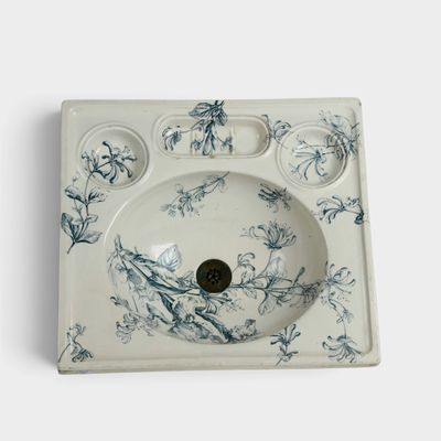 un évier blanc orné d'un motif floral bleu et blanc