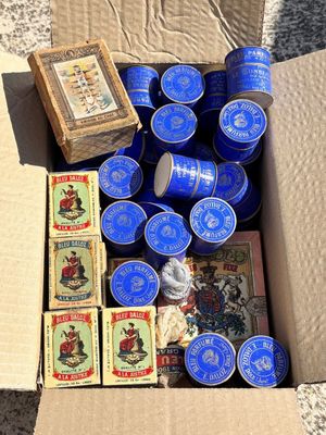 une boîte en carton remplie de boîtes de conserve bleues et d'autres objets