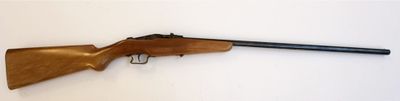 un fusil posé sur une surface blanche, avec une crosse noire