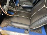a blue car with black leather seats and a steering wheel