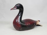 une image représentant une figurine de canard noir et rouge sur fond blanc