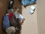 a cardboard box with clothes and a cell phone in it