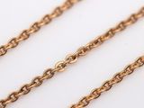 a close up of a gold chain on a white surface