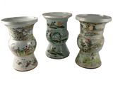 trois vases posés côte à côte sur une surface blanche
