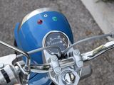 a close up of a blue motorcycle with a speedometer on it ' s handlebars