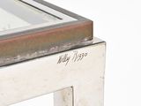 a close up of a metal table with a glass top