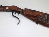 an old rifle with a wooden handle on a table