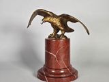 une image représentant une statue d'aigle posée sur un socle de marbre