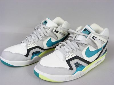 white and blue sneakers with green accents on a white surface