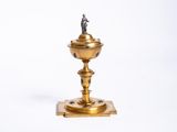 un bougeoir doré surmonté d'une statuette