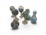 several glass vases are lined up in a row on a white surface