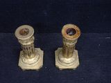 pair of antique brass candlesticks on a blue background