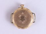 a small gold pocket watch on a white surface