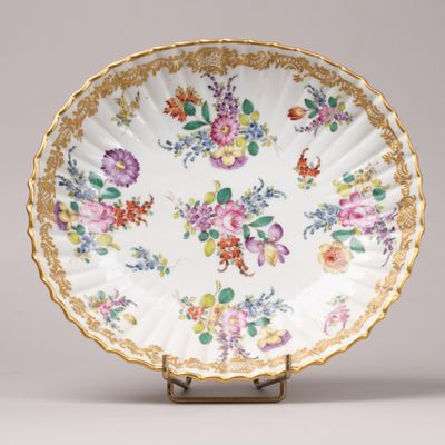 un gros plan d'une assiette décorée de fleurs, posée sur un support