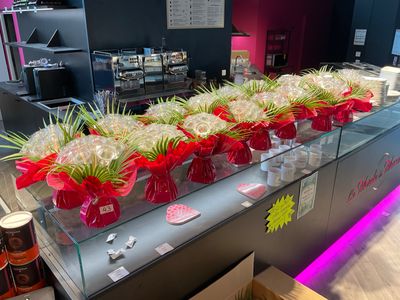 many vases of flowers on the counter in the store
