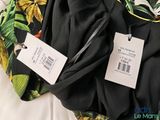 a black shirt with a floral print on it and a black tie with a white tag on it
