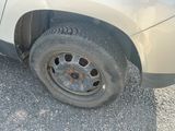 une voiture avec un pneu crevé, garée sur le bord de la route