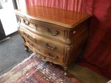 une commode en bois dans une pièce avec un rideau rouge