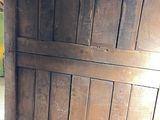 a cat that is sitting on the floor next to a wooden door