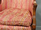 an antique chair with a striped upholstered seat and wood frame