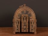 a small wooden clock on a table with a black background