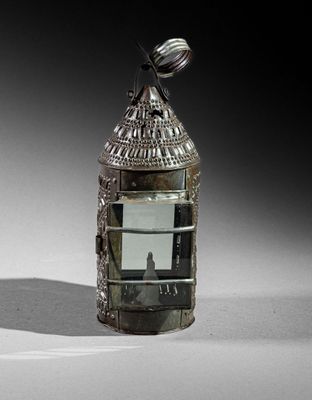 a small metal lantern with a bird on top of it