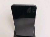 the back of a black cell phone sitting on top of a white table