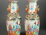pair of chinese vases with figures on them on a grey background