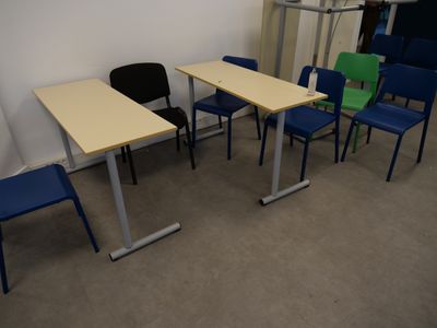 several chairs and tables in a room with a wall in the background