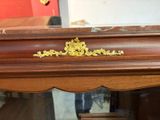 a close up of a wooden table with a gold decoration on it