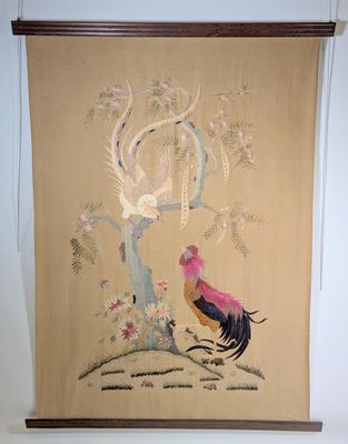 une tenture murale représentant un coq et un arbre