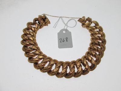 gros plan d'un bracelet en chaîne en or avec une étiquette de prix