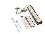 a clock, a pocket watch, a book, and a pen on a white surface
