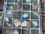 une boîte posée par terre, contenant des cailloux et des pierres