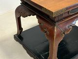 a wooden table with a black base and a brown top