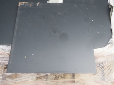 une photo d'un morceau de métal noir posé sur une table